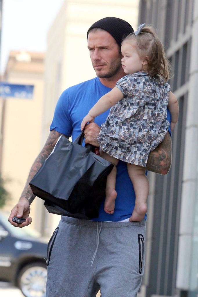Daddy's girl Harper Seven clings to dad David Beckham as the pair run errands in Los Angeles